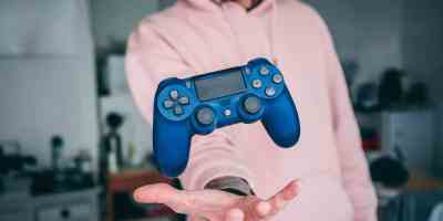 person holding blue Sony PS4 Dualshock 4 c